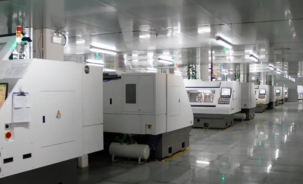 Row of automated CNC machines in a cleanroom facility for high-precision printed circuit board manufacturing.