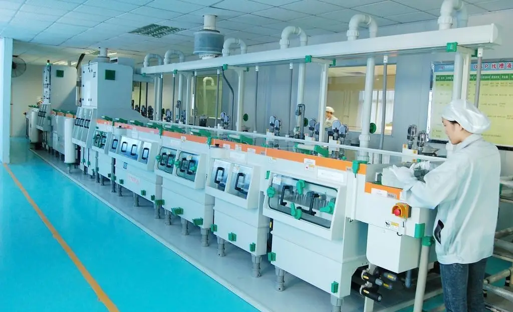 Worker operates an automated OSP (Organic Solderability Preservative) production line for PCB surface finishing in a clean manufacturing plant.