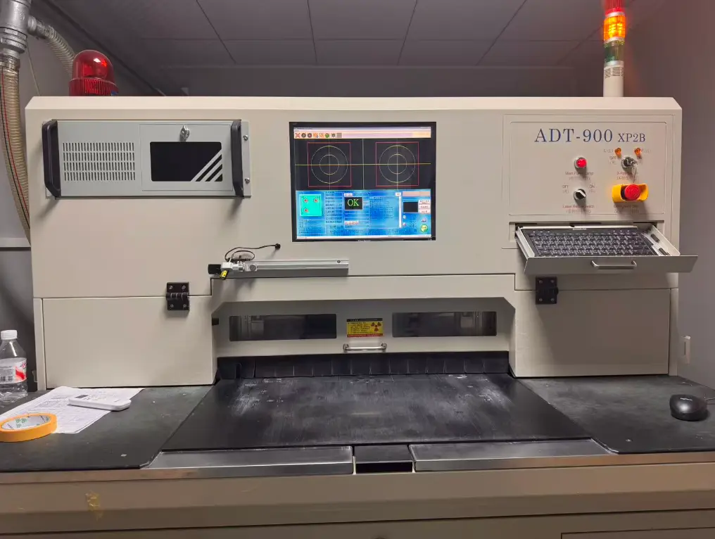 ADT-900 XP2B automated precision machine for PCB fabrication, featuring a control screen and safety lights, optimizing circuit board manufacturing.