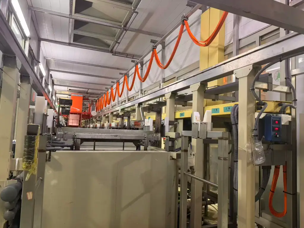 Automated PCB electroplating line with tanks and overhead gantry system, optimizing circuit board fabrication efficiency and quality.